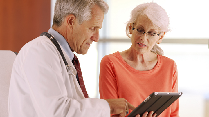 Doctor using Patient Information Exchange to help a senior patient.